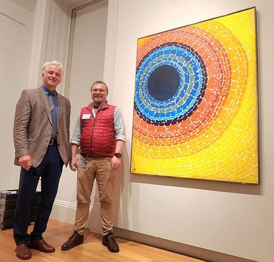 两个男人站在一件艺术品旁